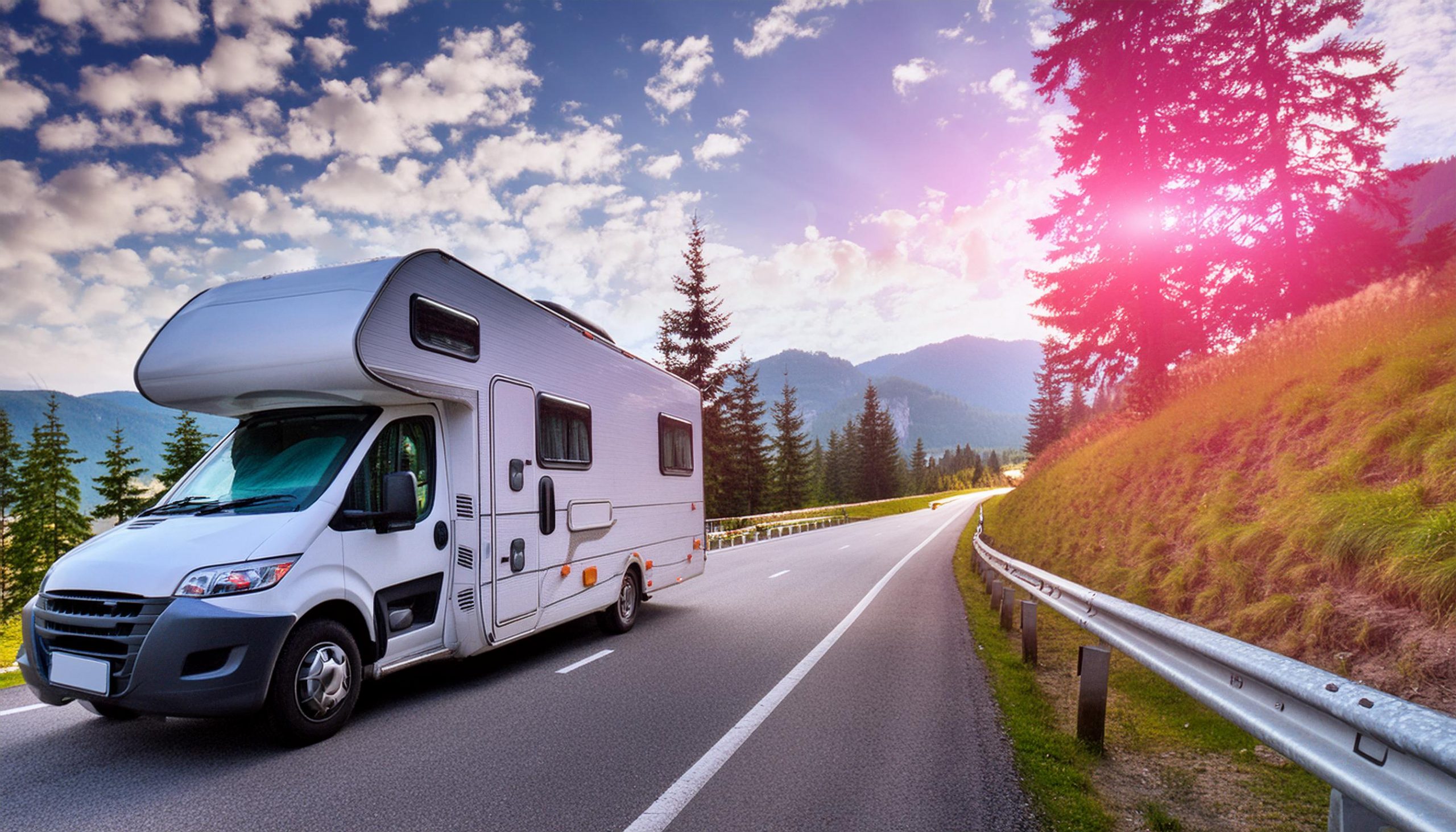 an image of an RV on a scenic road with a lens flare coming through the pine trees